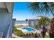 View of the shared community pool with beach access beyond the palm trees and coastal property at 7000 Gulf Dr # 205, Holmes Beach, FL 34217