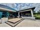 Exterior view of building with dining area, large glass windows, and stairs at 7330 Kensington Ct, University Park, FL 34201