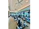 Well-lit gym with multiple machines, fans, and TVs overlooking the landscape at 7330 Kensington Ct, University Park, FL 34201