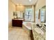Inviting bathroom featuring dual vanities, a soaking tub, and a bright window offering serene views at 7330 Kensington Ct, University Park, FL 34201