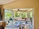 Enclosed lanai with tiled floors, a ceiling fan, and views of lush greenery at 7330 Kensington Ct, University Park, FL 34201
