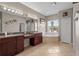 Main bathroom featuring dual vanities, soaking tub, and bright natural light at 7626 Double Pine Dr, Sarasota, FL 34240