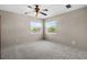 Bright bedroom with ceiling fan, two windows, and neutral carpet at 7626 Double Pine Dr, Sarasota, FL 34240
