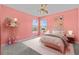 Stylized bedroom features windows, colorful décor, plush carpet and bed with playful artwork at 7626 Double Pine Dr, Sarasota, FL 34240