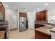 Kitchen area with stainless steel fridge, tile backsplash, and breakfast bar in this spacious layout at 7626 Double Pine Dr, Sarasota, FL 34240