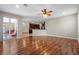 Spacious living room with beautiful wood floors, ceiling fan, and access to a screened patio and kitchen at 7626 Double Pine Dr, Sarasota, FL 34240
