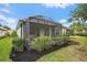 The backyard has green grass, hedges, a screened lanai and mature trees at 7821 Troon Ct, Lakewood Ranch, FL 34202