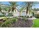 Inviting single-story home with palm trees, a well-manicured lawn, and a walkway leading to the front door at 7821 Troon Ct, Lakewood Ranch, FL 34202