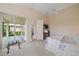 A bright main bedroom features access to the screened lanai with a ceiling fan at 7821 Troon Ct, Lakewood Ranch, FL 34202
