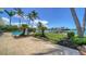 Beautiful backyard with a refreshing pool, a boat dock, and lush tropical landscaping with palm trees at 878 Freeling Dr, Sarasota, FL 34242