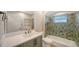 Bathroom with custom green and blue tiles, white quartz countertops, and brushed metal fixtures at 878 Freeling Dr, Sarasota, FL 34242
