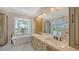 Bathroom with double sinks, granite countertops, tub, bay window, and backyard views at 878 Freeling Dr, Sarasota, FL 34242