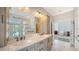 Bathroom featuring double sinks, marble tile floors, and access to the bedroom at 878 Freeling Dr, Sarasota, FL 34242