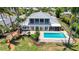 Beautiful two-story home with a pool, manicured lawn, and lush tropical landscaping creating a private oasis at 878 Freeling Dr, Sarasota, FL 34242