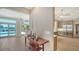 Hallway with decorative wood table and view to the kitchen and living room with pool access at 878 Freeling Dr, Sarasota, FL 34242