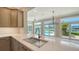 Spacious kitchen with stone countertops, stainless steel appliances, and island with bar seating overlooking pool at 878 Freeling Dr, Sarasota, FL 34242