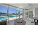 Enjoy the screened-in patio featuring comfortable furniture, a fire pit, and a view of the pool and waterfront at 878 Freeling Dr, Sarasota, FL 34242