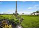 Landscaped backyard with lush green grass, lovely garden and unobstructed water views at 910 Tidewater Shores Loop # 103, Bradenton, FL 34208