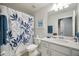 Bathroom featuring a shower/tub combo with leaf-patterned curtain and bright vanity at 910 Tidewater Shores Loop # 103, Bradenton, FL 34208
