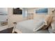 Bright bedroom features a mounted television, coastal decor, and hardwood floors at 910 Tidewater Shores Loop # 103, Bradenton, FL 34208