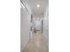 Hallway boasts neutral paint with tile flooring, a hall chest and access to a kitchen and other rooms at 910 Tidewater Shores Loop # 103, Bradenton, FL 34208