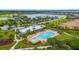 Aerial shot of a community pool and recreation center with lush landscaping and water views at 910 Tidewater Shores Loop # 103, Bradenton, FL 34208