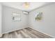 Simple bedroom with light walls, vinyl floors, two windows, and an air conditioner at 920 Myrtle Ave, Venice, FL 34285