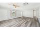 Bright living room featuring modern gray wood flooring, a ceiling fan, and a large window providing ample natural light at 920 Myrtle Ave, Venice, FL 34285