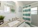 Bright bathroom featuring white subway tile, a blue striped shower curtain, and granite vanity at 102 & 104 48Th St, Holmes Beach, FL 34217