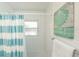 Bright bathroom featuring white subway tile, a blue striped shower curtain, and a seashell-themed art print at 102 & 104 48Th St, Holmes Beach, FL 34217
