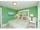 Bright bedroom featuring green walls, a patterned quilt, and white trim, creating a cozy and inviting atmosphere at 102 & 104 48Th St, Holmes Beach, FL 34217