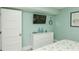 Bright bedroom with a white dresser and television, complemented by charming coastal decor and ample natural light at 102 & 104 48Th St, Holmes Beach, FL 34217