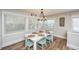 Charming dining area with seating for six, wood-look tile flooring, and coastal decor at 102 & 104 48Th St, Holmes Beach, FL 34217