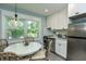 A quaint kitchen with stainless steel appliances, white cabinets and a cozy breakfast nook at 102 & 104 48Th St, Holmes Beach, FL 34217
