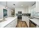 This modern kitchen is complete with stainless steel appliances, white cabinetry, and a breakfast bar at 102 & 104 48Th St, Holmes Beach, FL 34217