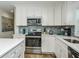 Modern kitchen with stylish tile backsplash, stainless steel appliances, and bright countertops at 102 & 104 48Th St, Holmes Beach, FL 34217
