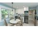 A bright kitchen with stainless steel appliances, white cabinets and a breakfast nook by the window at 102 & 104 48Th St, Holmes Beach, FL 34217