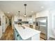 Bright kitchen boasts modern white cabinets, stainless appliances, pendant lights, and stylish breakfast bar at 102 & 104 48Th St, Holmes Beach, FL 34217