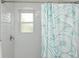 Bright shower featuring white subway tile, a window, and a teal shower curtain at 102 & 104 48Th St, Holmes Beach, FL 34217