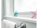 Close-up of a bathroom window featuring a cheerful starfish and a neutral towel at 102 & 104 48Th St, Holmes Beach, FL 34217