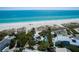 Stunning aerial view of a beachfront home with a pool, clear blue water, and white sandy beach at 102 & 104 48Th St, Holmes Beach, FL 34217