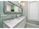 Elegant bathroom featuring double sinks, marble countertops, and textured wallpaper at 102 & 104 48Th St, Holmes Beach, FL 34217