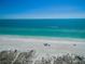 Scenic beachfront with clear turquoise water, white sand, and a boat in the distance at 102 & 104 48Th St, Holmes Beach, FL 34217