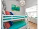 Bunk bedroom with white wood paneled walls, ladder, and colorful accents at 102 & 104 48Th St, Holmes Beach, FL 34217