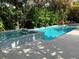 Serene pool and spa area with stylish tile work, lush greenery, and inviting lounge chairs at 102 & 104 48Th St, Holmes Beach, FL 34217