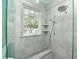 Modern shower with marble tile, built-in shelving, and a rainfall shower head at 102 & 104 48Th St, Holmes Beach, FL 34217