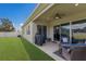 Covered patio and backyard featuring well-maintained lawn, barbecue grill, and lush landscaping at 11513 11Th E Ave, Bradenton, FL 34212