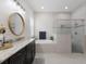Bright bathroom featuring a soaking tub, glass enclosed shower, marble countertops, and a large round mirror at 11513 11Th E Ave, Bradenton, FL 34212
