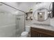 Bathroom featuring glass enclosed shower, granite countertops, a round mirror, and decorative floating shelves at 11513 11Th E Ave, Bradenton, FL 34212