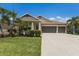 Beautiful home featuring a three-car garage, manicured landscaping, and a welcoming front porch at 11513 11Th E Ave, Bradenton, FL 34212